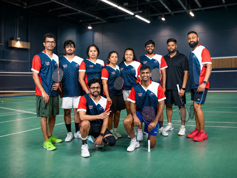Feather Fires team in navy and red jerseys posing on court