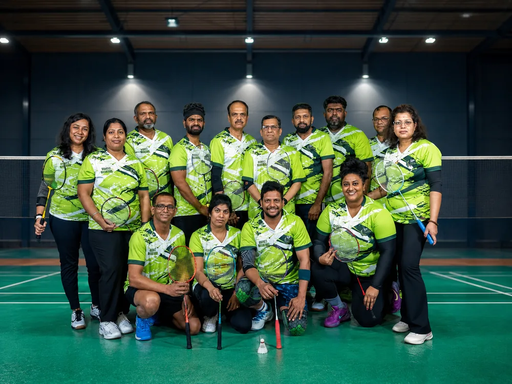 Team in green jerseys posing together on court